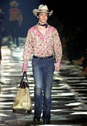 Con música del oeste americano como telón de fondo y algún que otro sombrero vaquero, los modelos de Gucci, pensados como síntesis del Nuevo y el Viejo Continente, llevan pantalones tejanos planchados con raya y ceñidos para realzar unas omnipresentes botas camperas.