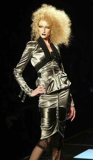 El otro elemento básico del verano Dior 2004, subrayado por el propio Galliano, fue el de las texturas y colores metalizados, en biquinis, faldas, corsés, blusas drapeadas y vestidos de bajos irregulares. Aunque el pantalón brilló por su ausencia, Galliano optó él por un traje pantalón de satén plateado, sin blusa ni camisa, directamente sobre el torso.