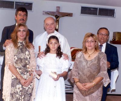 La niña Irma Román García en su Primera Comunión en la capilla de San Belarmino acompañada de sus padres y padrinos.