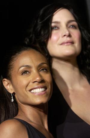 Jada Pinkett Smith y Carrie-Anne Moss posan juntas para los fotógrafos.