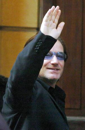 Bono, líder del grupo U2 saluda a los fotógrados a su arrivo la boda del tenor italiano.