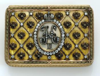 Encargados por primera vez por el zar ruso Alejandro III en 1885 como regalo de Pascua para su esposa, Maria Feodorovna, la tradición de los huevos elaborados por la firma Fabergé fue continuada por su hijo y sucesor, Nicolás II, convirtiéndose en una tradición familiar que se prolongó 30 años.
 Imagen:La caja de la coronación 