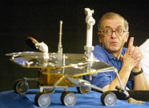 Charles Elachi, director del laboratorio de propulsion de la NASA muestra una reproducción del Rover Spirit durante una conferencia de prensa.
