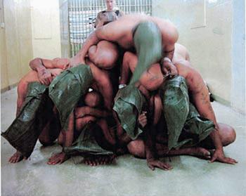Una foto muestra prisioneros iraquíes, desnudos y encapuchados, apilados en una pirámide humana y uno de ellos con un insulto en inglés escrito en la piel. 


Las imágenes incluían la de un soldado británico orinando sobre un iraquí encapuchado y en cuclillas. 
 
Además los soldados estadounidenses amenazaban a los hombres de violación.