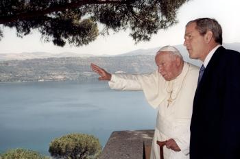 2001file photo of pope john paul ii gesturing from the balcony of his summer residence in castelgandolfo, alongside u.s. president george w. bush north of rome, on july 23, 2001