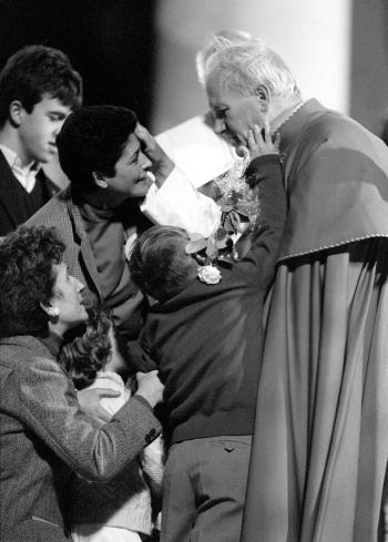 Una mañana de enero de 1980, un niño de 11 años preguntó a Juan Pablo II en una parroquia romana: “Santo Padre, ¿por qué está siempre viajando por el mundo?” La respuesta de Juan Pablo II al niño romano fue rápida: “El Papa viaja tanto, porque no todo el mundo está aquí (en Roma)”.

Esta foto fue  tomada el seis de noviembre de 1982  cuando el Papa Juan pablo II recibió el homenaje de un grupo de enfermos mentales en el estadio de la Romareda.