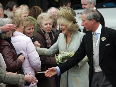 Al término de la ceremonia, Carlos y Camilla salieron sonrientes ante una multitud que, con banderas británicas, les saludó al pie de las escalinatas de esta capilla medieval.