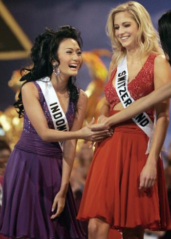 Artika Sari Devi de Indonesia celebra el pase de la representante de Suiza entre las 15 semifinalistas del certamen de belleza.