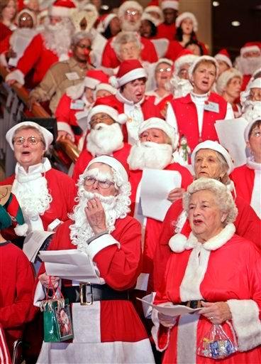 Vestidos de Santa Claus, miembros del grupo de caridad Goodwill Santa cantan a las afueras de un hotel en Tokio, Japón.