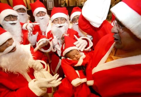 Trabajadores de un hotel de Yakarta, Indonesia, posan vestidos de Santa Claus con el bebé de uno de ellos durante la celebración navideña .