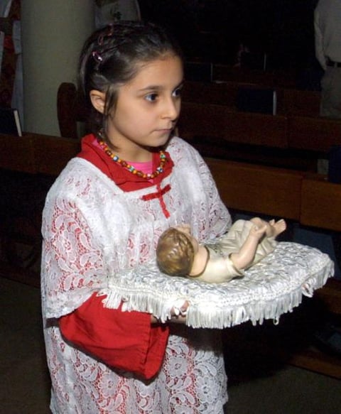 Una niña iraquí cristiana lleva una figura del niño Jesús durante la celebración de una oración en la Iglesia del barrio de Karrada, en el centro de Bagdad, Irak.