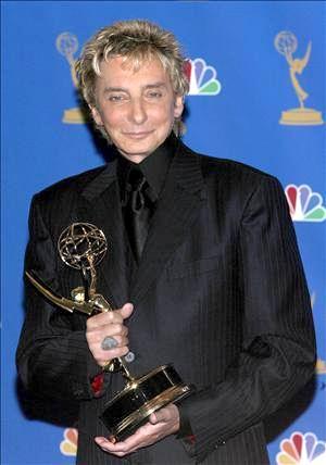 El músico estadounidense Barry Manilow (foto) sostiene su galardón como Mejor actuación individual en un programa de variedades o musical por su show Barry Manilow Music and Passion.
