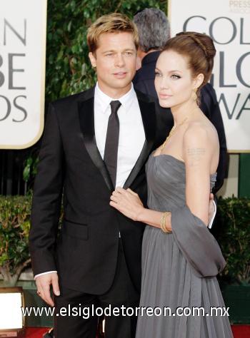 Angelina Jolie, con un vestido gris oscuro de St. John, marca para la cual modela. Aquí junto a su pareja, el actor de 'Babel', Brad Pitt, nominado como mejor actor de reparto .
