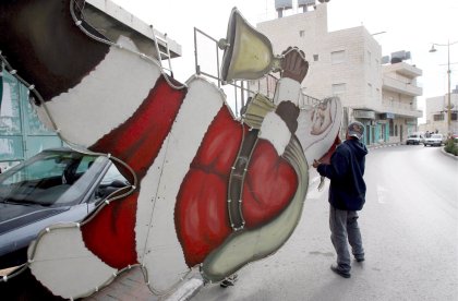 Un hombre transporta una figura gigante de papa Noel en la ciudad Cisjordana de Belén. Un año más se esperan en navidad gran cantidad de turistas ya que la ciudad de belén es conocida como lugar de nacimiento de Jesucristo.