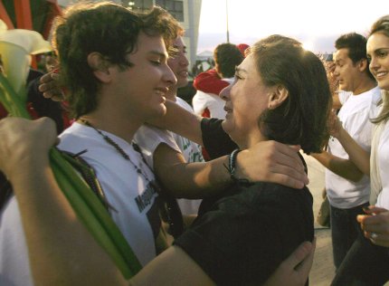 La ex parlamentaria colombiana Gloria Polanco de Lozada abraza a uno de sus hijos, tras el aterrizaje del avión que llevó a los cuatro ex congresistas a la capital venezolana.