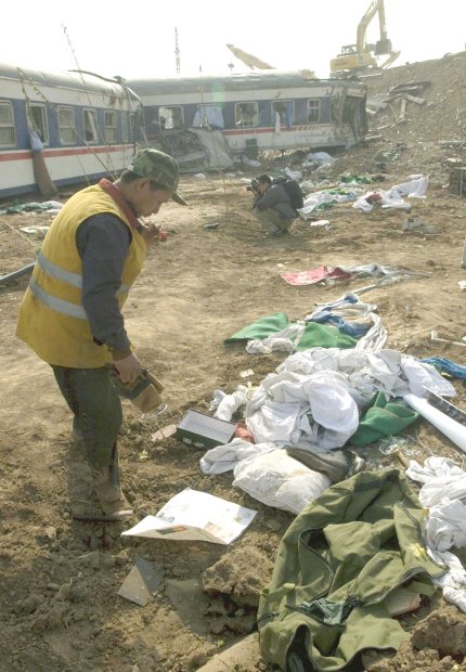 Un trabajador del ferrocarril observa las pertenencias de los viajeros en el lugar donde han descarrilado dos trenes de pasajeros cerca de la ciudad de Zibo, en la provincia de Shandong, al noreste de China.