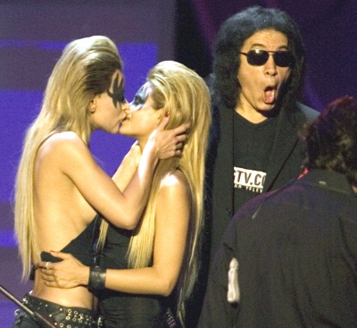 Gene Simmons, vocalista de la legendaria banda Kiss, le pidió un beso a sus dos acompañantes. Al acercarse éstas, él se salió y ellas siguieron el movimiento hasta besarse en la boca.