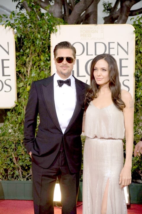 Angelina Jolie capturó la atención con un vestido largo marfil suelto y abierto a media pierna. Brad Pitt acudió con un esmoquin negro y lentes de aviador.