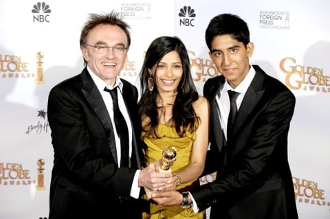 El director británico de cine Danny Boyle posa junto a los actores Freida Pinto y Dev Patel tras recibir el premio a Mejor director.