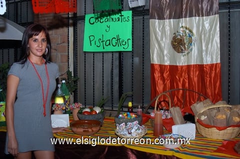 17092009 Tania Ortiz junto a una mesa decorada al estilo mexicano con antojitos y dulces típicos.