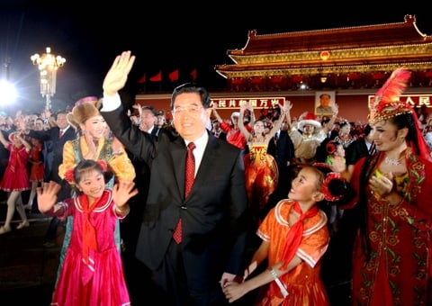 El presidente Hu Jintao, que vestía un saco al estilo Mao en vez de un traje de gala occidental, iba a bordo de una limosina con una bandera roja para pasar revista a los miles de soldados.
