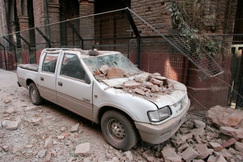 Un vehículo es impactado por escombros  en Santiago Chile, tras el fuerte terremoto de 8,3 grados en la escala Richter que azotó el 80 por ciento del país.