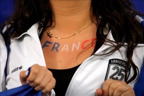 Una aficionada francesa lleva el nombre de su país pintado debajo del cuello.