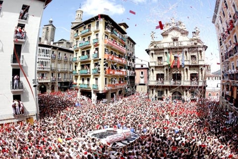 Miles de personas se reunieron en la plaza principal de Pamplona para festejar el inicio de los Sanfermines con vino espumoso y juegos pirotécnicos.