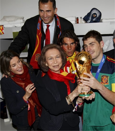 La reina Sofía y el guardameta español Iker Casillas con la Copa del Mundo, en presencia de los Príncipes de Asturias y el tenista Rafael Nadal, en el vestuario de la selección española de fútbol.