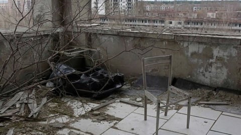 Desde el balcón de un edificio abandonado es posible observar el sarcófago sobre la usina de Chernobyl, que, después de 25 años, todavía necesita reforzar la estructura para contener la radiactividad.