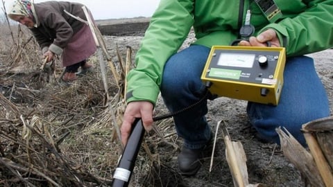La ucraniana Ganna Zavorotnya, 78 años, en un predio rural, mientras un técnico de Greenpeace mide niveles de radiación, en la aldea de Kupovate, localizada a 30 Km de la usina nuclear de Chernobyl.
