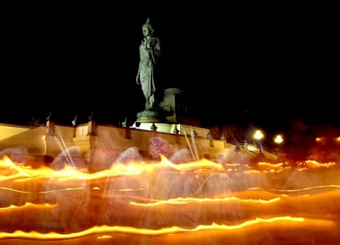 Devotos budistas encienden velas frente a la gran estatua de Buda del sagrado lugar de Buddhamonthon, en Tailandia.