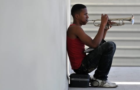 Un joven toca trompeta en el portal de un edificio en La Habana (Cuba).