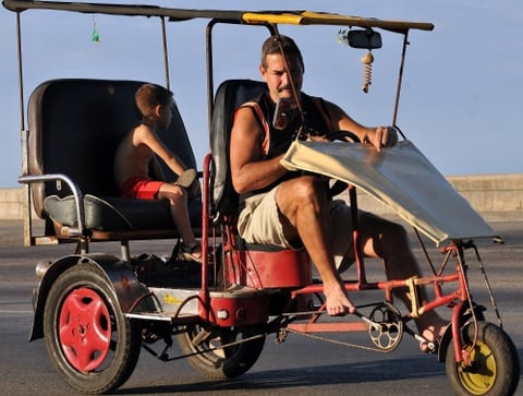 Un hombre viaja con su hijo en un bicitaxi en La Habana, Cuba.