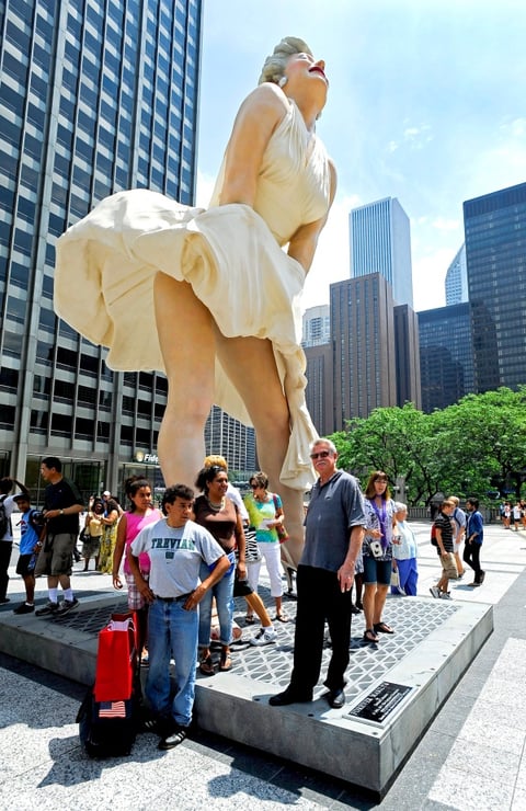 Visitantes posan debajo de una estatua gigante de la actriz Marilyn Monroe.