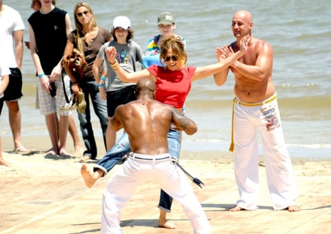 Jennifer López se apareció  en una playa uruguaya con top rojo y jeans, bailó capoeira entusiasmando a testigos, y se retiró repartiendo sonrisas.