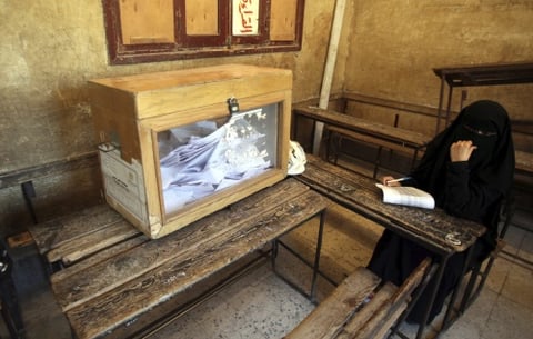 Una mujer egipcia del brazo político de la organización islamista de los Hermanos Musulmanes, el Partido Libertad y Justicia, observa la votación en un colegio electoral en El Cairo.