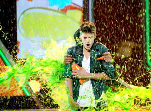 La lluvia verde llegó rápida y furiosa a la 25ta entrega de los Premios Kids' Choice, donde incluso las celebridades son bañadas con cubos de la temida pero esperada sustancia pegajosa.
