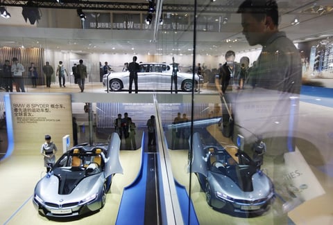 Unos visitantes observan el prototipo BMW i8 Spyder en el Salón del Automóvil de China.