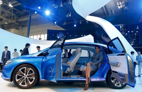 Una modelo posa en el interior de un prototipo eléctrico de la marca Denza en el Salón del Automóvil de China.