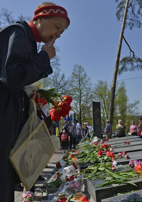 Una viuda sostiene un retrato de su marido durante una ceremonia en memoria de las víctimas de la catástrofe nuclear de Chernóbil en Kiev, Ucrania.