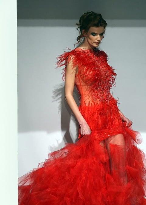 Una modelo luce una roja creación de las diseñadoras bielorrusas Marina, Olga y Elena Parfenovich.