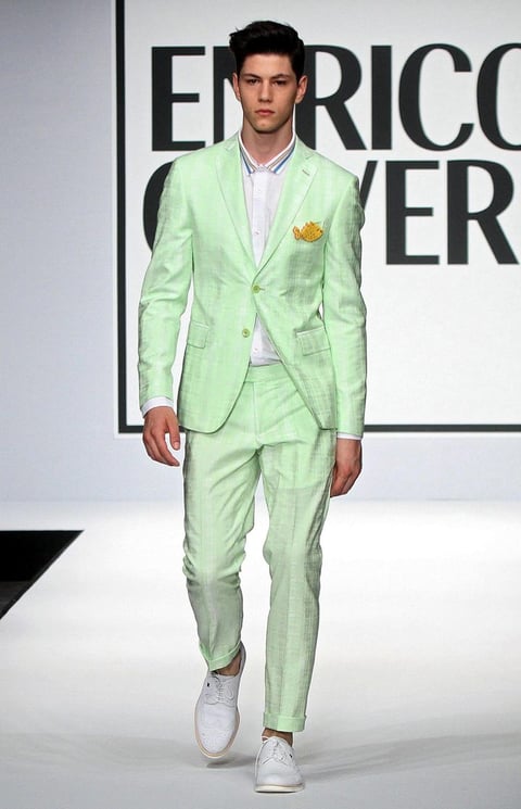 Un modelo desfila un traje color verde limon de la firma Enrico Coveri.