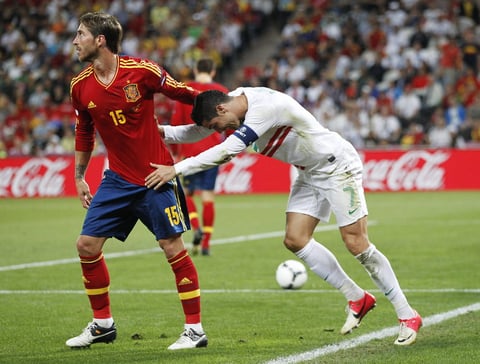 Compañeros en el Real Madrid, Cristiano Ronaldo y el español Sergio Ramos interactúan en el enfrentamiento deportivo entre sus países. (EFE)