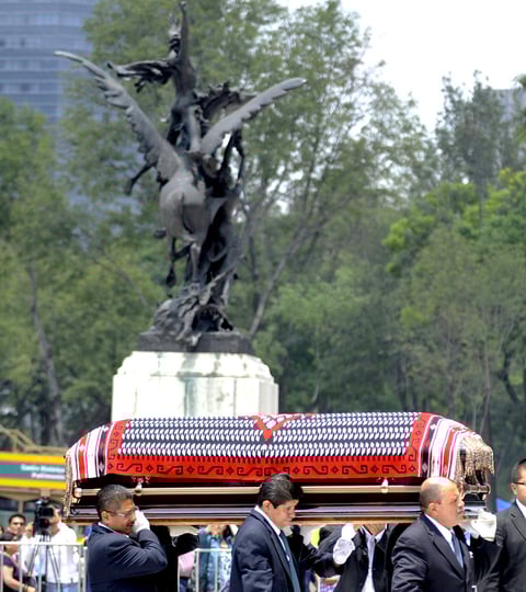 La caja está cubierta por su huipil tejido de colores blanco y negro, con las orillas rojas, las flores sobre el féretro conmocionan al público que se encontraba al centro del recinto, de antemano una fila de seguidores desea despedirse de Chavela Vargas en el Palacio de Bellas Artes.