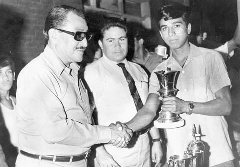 FELICIANO Soto Reyes recibe trofeo que acredita al equipo San José como campeón de torneo de baby-fut en la escuela Constituyentes de 1917. Lo entrega el señor Enrique Muñoz y Lorenzo Hernández en el año de 1969.