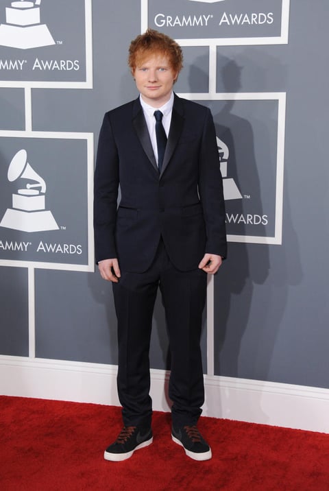 El cantante Ed Sheeran desfiló por la alfombra roja de los Grammy con un traje negro y tenis.