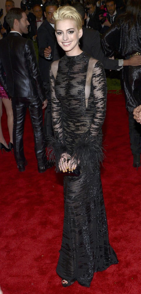 Anne Hathaway optó por un Valentino vintage de 1992, negro de transparencias jaspeadas, completado por el pelo decolorado y maquillaje estudiadamente corrido.
