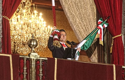El mandatario tomó con fuerza la Bandera nacional para salir al balcón. Entonces hizo sonar nueve veces la campana de Dolores y arengó a miles.