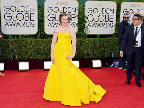 Lena Dunham luciendo un llamativo vestido amarillo.
